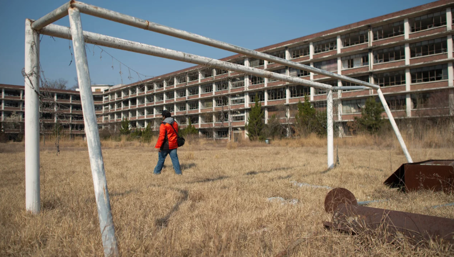 Um fotógrafo do lado de fora de uma escola abandonada perto de Daejeon, Coreia do Sul, em 22 de março de 2014. / Ed Jones/AFP/Getty Images