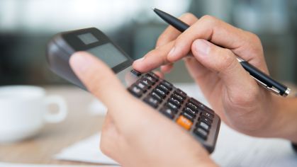 Close-up of male hands using calculator. Unrecognizable accountant holding pen when pushing button on calculator. Finance concept