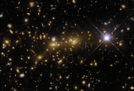 Hubble captura imagem de “lente gravitacional” que amplia objetos distantes em aglomerado de galáxias