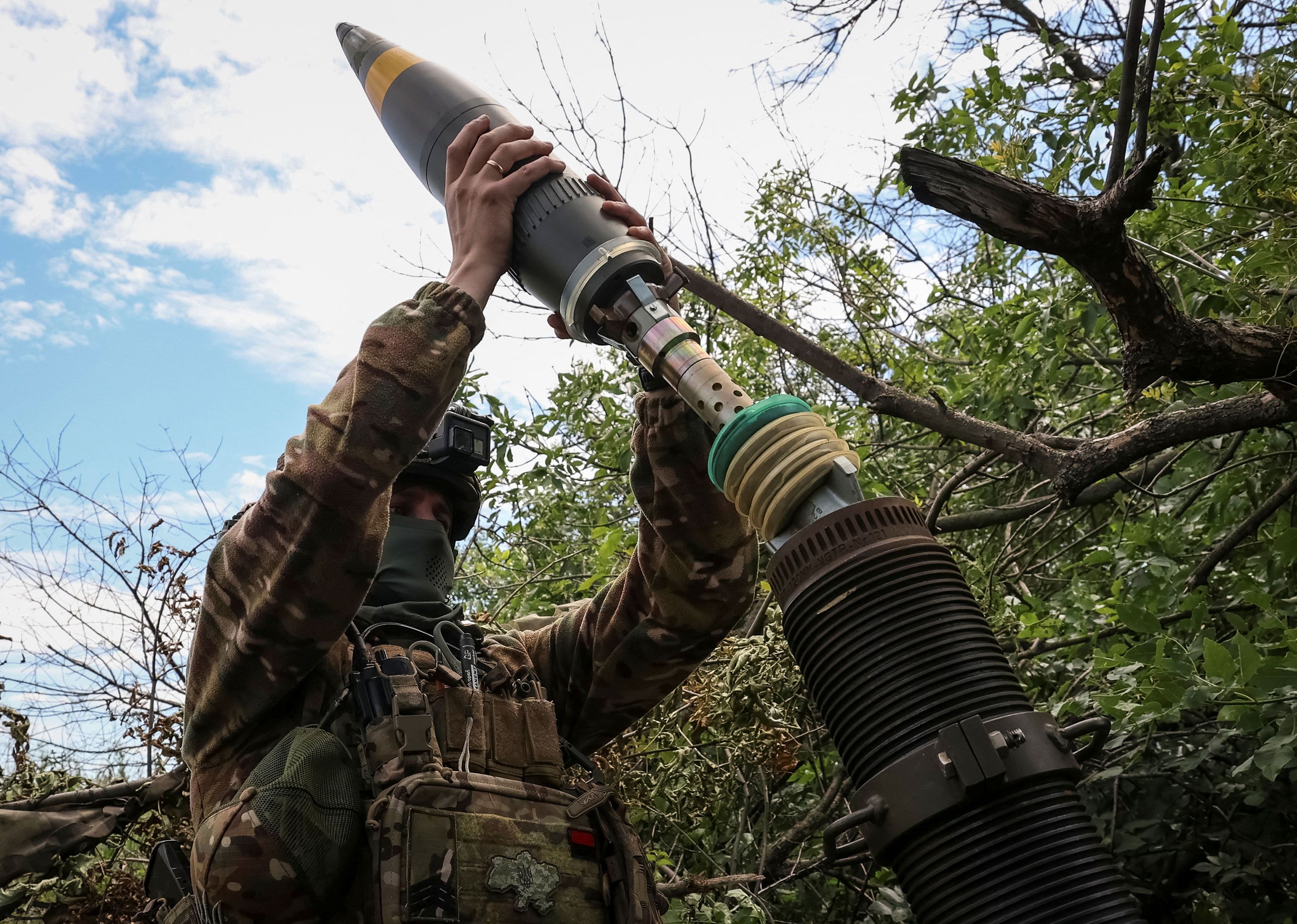 Ukrainian service members fire a mortar at a front line near the city of Bakhmut