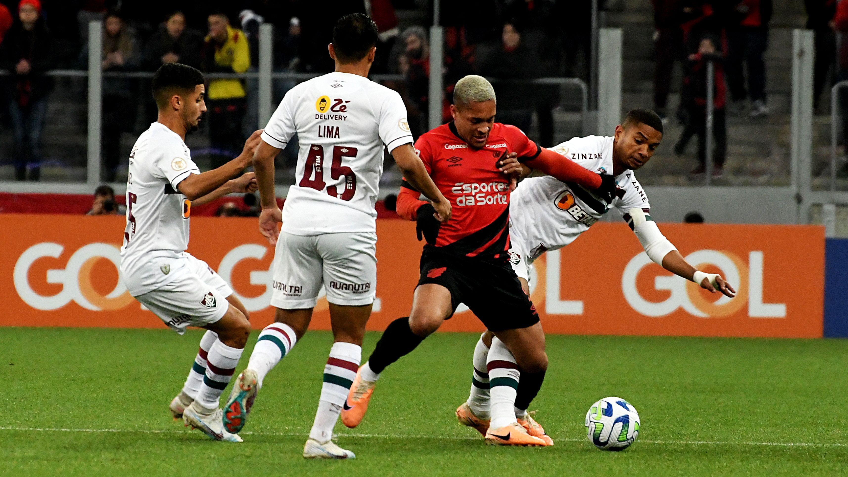 Vitor Roque, do Athletico-PR, é cercado por jogadores do Fluminense