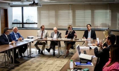 Pessoas se reúnem ao redor de mesa e debatem novo teto para MEIs em reunião do MDIC com o Comitê Técnico MEI, do Fórum Permanente das Microempresas e Empresas de Pequeno Porte (FPMPE)