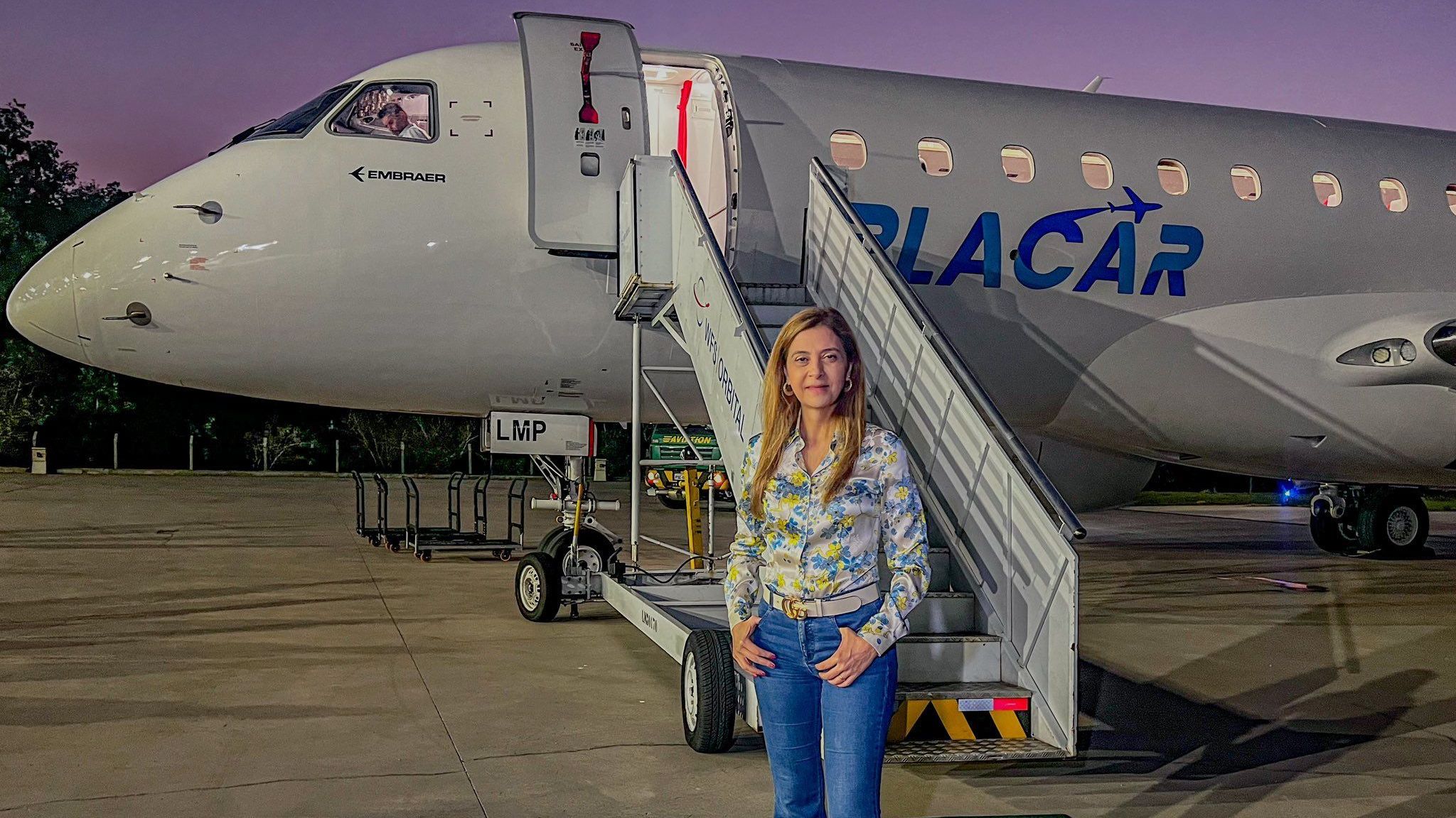 Leila Pereira, presidente do Palmeiras, posa em frente ao avião dela