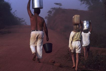 Família de pai e filhas carregam balde d&#039;água na rodovia Transamazônica, no estado do Pará, na Amazônia brasileira, em novembro de 2017.
