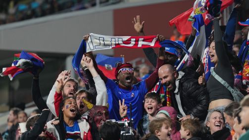 Torcedores do Haiti festejam nas arquibancadas durante jogo contra a Dinamarca