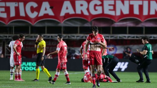Luciano Sánchez no chão, enquanto os jogadores mostram desespero