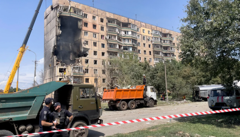 Policiais montam guarda perto de um prédio residencial parcialmente destruído como resultado de um ataque de míssil russo em Kryvyi Rih em 31 de julho de 2023. / AFP/Getty Images