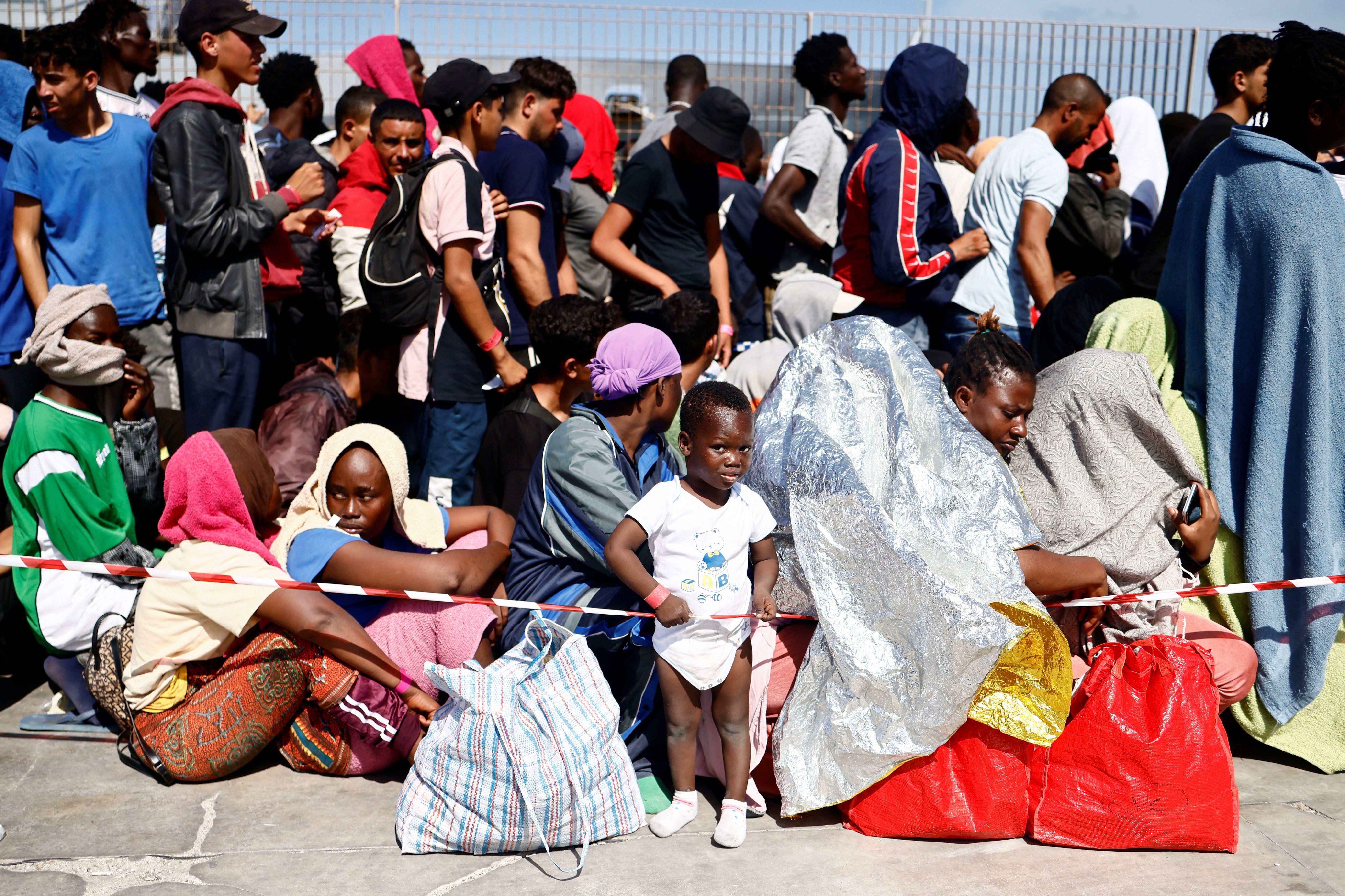 Imigrantes aguardam transferência para o continente no porto da ilha italiana de Lampedusa