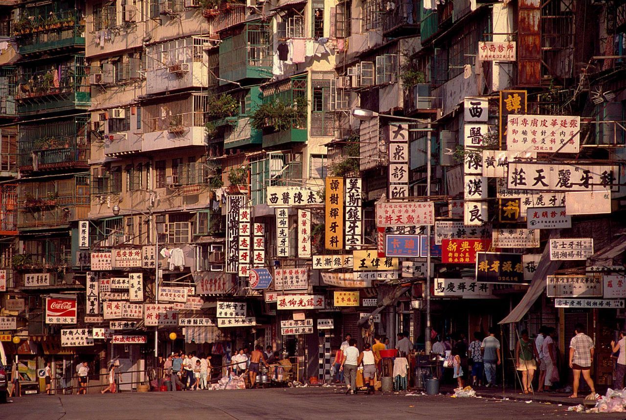 "Cidade Murada, Estrada Tung Tau Tsuen" (1987) por Greg Girard. Placas em preto e branco anunciam consultórios de dentistas e médicos operando no interior / Greg Girard/Blue Lotus Gallery
