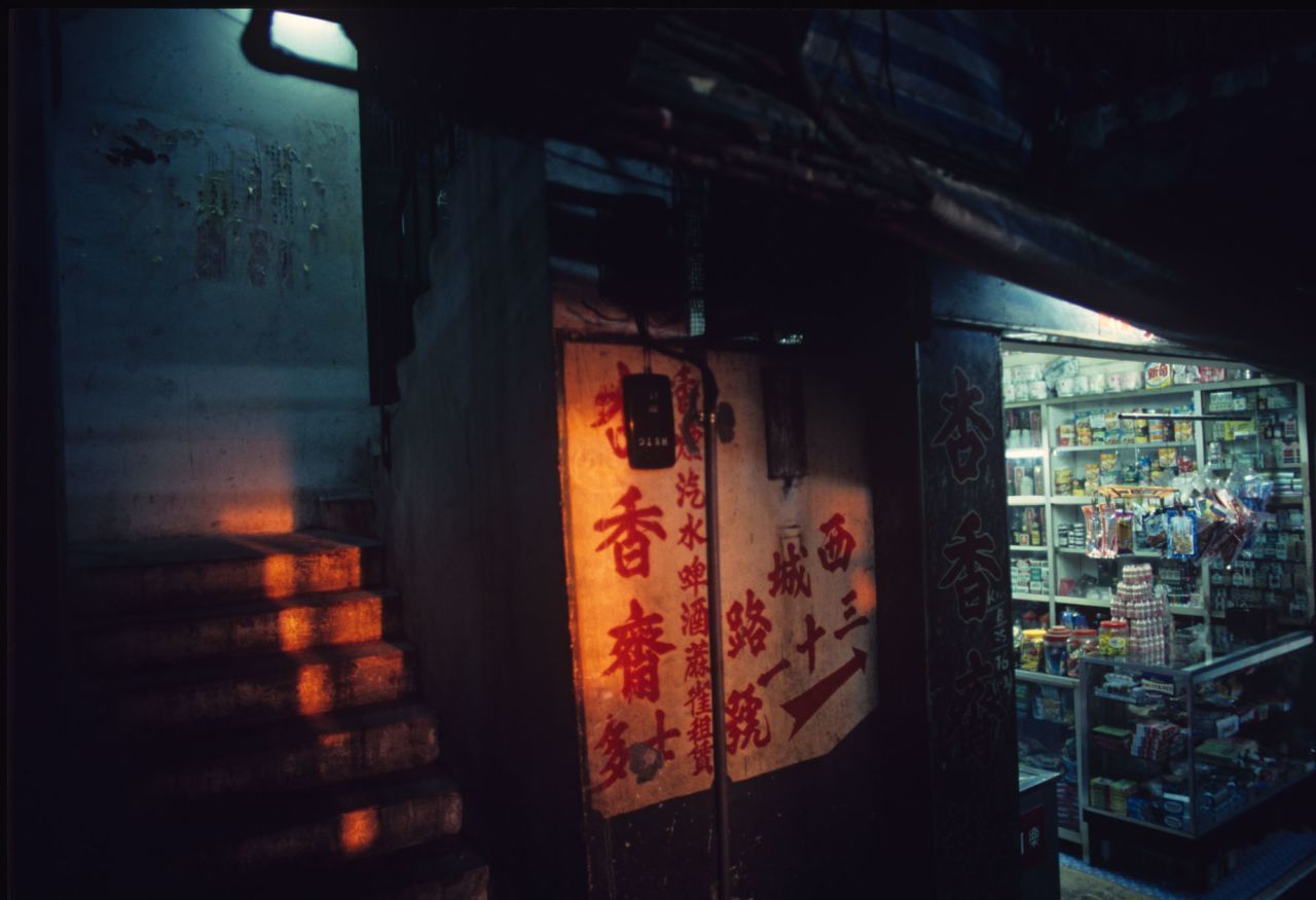 "Cidade Murada de Kowloon, vista de um beco" (1990) por Greg Girard / Greg Girard/Blue Lotus Gallery
