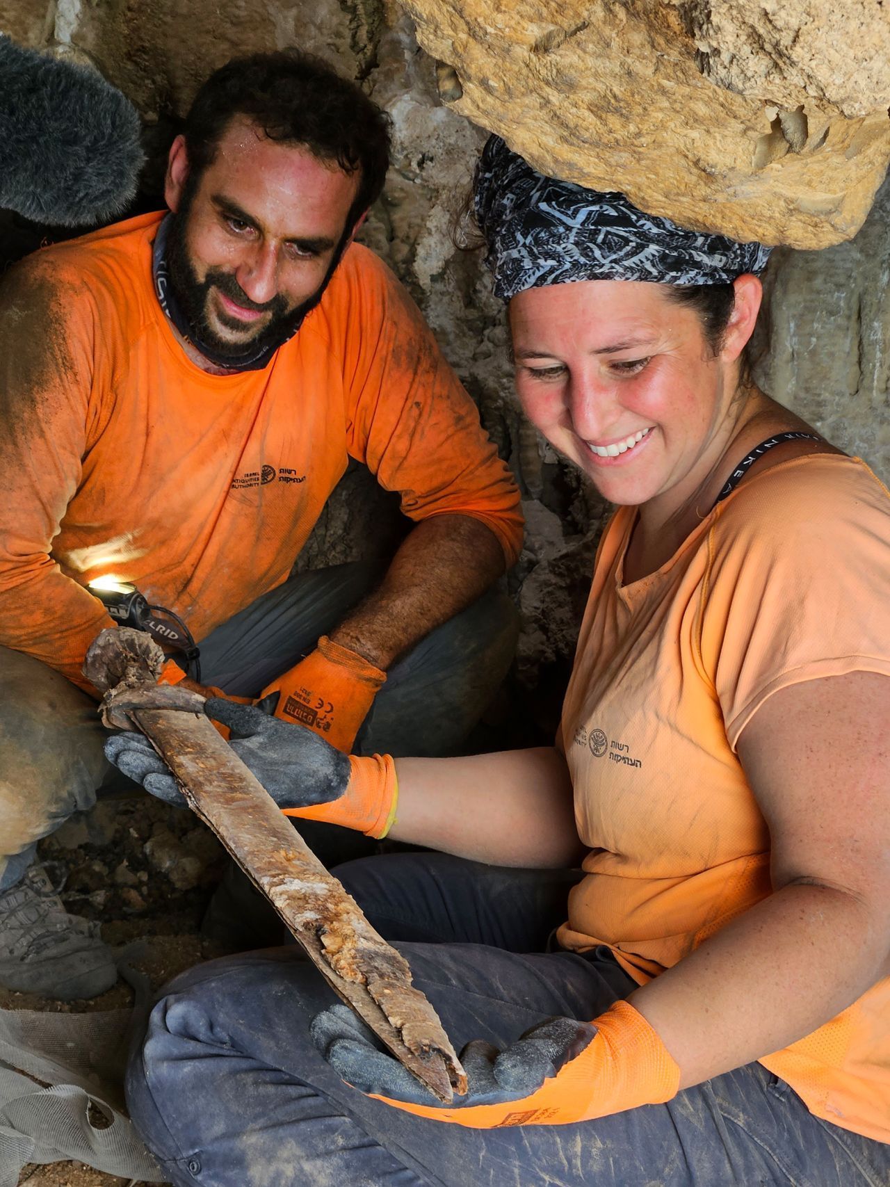 Os arqueólogos Oriya Amichay (direita) e Hagay Hamer (esquerda) com uma das espadas. / Amir Ganor/Israel Antiquities. Authority