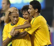 Alexandre Pato e Paulo Henrique Ganso abraçam Neymar na estreia do meia-atacante pela Seleção, em agosto de 2013.