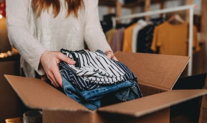 A millennial woman is preparing the shipment of some clothes in her new online shop