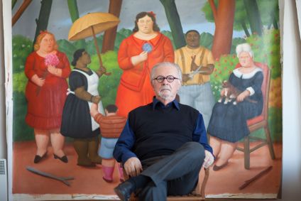 Pintor e escultor colombiano Fernando Botero sentado em seu estúdio em frente a uma pintura que retrata um grupo em um jardim, em Monte Carlo, em março de 2012.