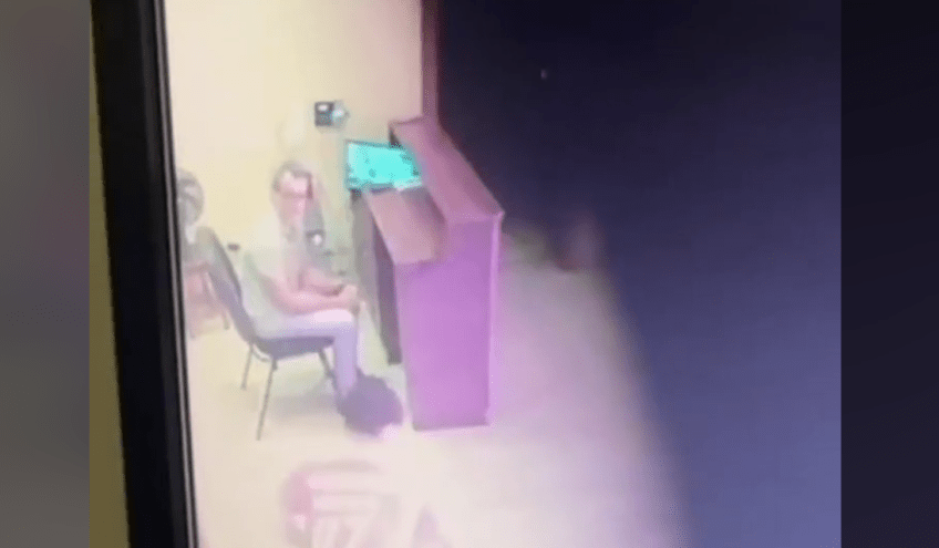 Imagens de uma câmera de segurança mostram o momento no qual o homem espanca o ator Victor Meyniel, que se encontra deitado do chão da portaria, enquanto o porteiro do prédio assiste à cena sem tomar nenhuma providência. / Reprodução