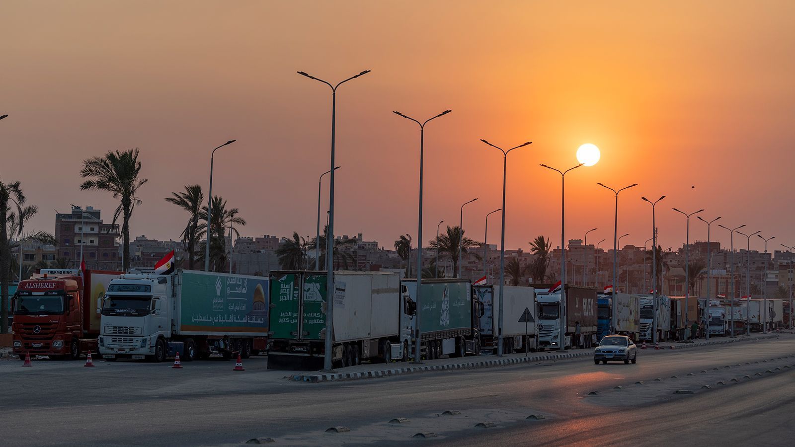 Caminhões de comboio de ajuda carregados com suprimentos são vistos em El-Arish, Egito, esperando a abertura da fronteira Gaza-Egito em 15 de outubro de 2023 no Sinai do Norte, Egito. O comboio de ajuda, organizado por um grupo de ONG egípcias, partiu hoje do Cairo para a passagem da fronteira Gaza-Egito em Rafah. No dia 7 de Outubro, o grupo militante palestiniano Hamas lançou um ataque surpresa às comunidades fronteiriças no sul de Israel, estimulando o recrudescimento mais violento do conflito Israel-Palestina em décadas. Israel lançou uma vasta campanha de bombardeamentos em retaliação e alertou sobre uma iminente invasão terrestre.