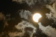 Eclipse solar parcial é visto por entre nuvens na cidade de Socorro, interior de São Paulo, na tarde deste sábado