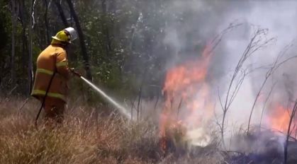 Bombeiro apaga chamas durante incêndio florestal em Queensland, na Austrália