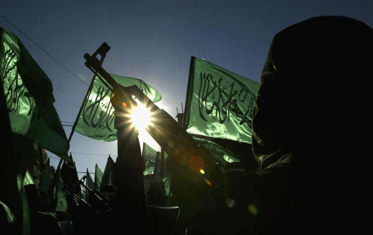 Membros do Hamas mascarados exibem armas / Abid Katib/Getty Images