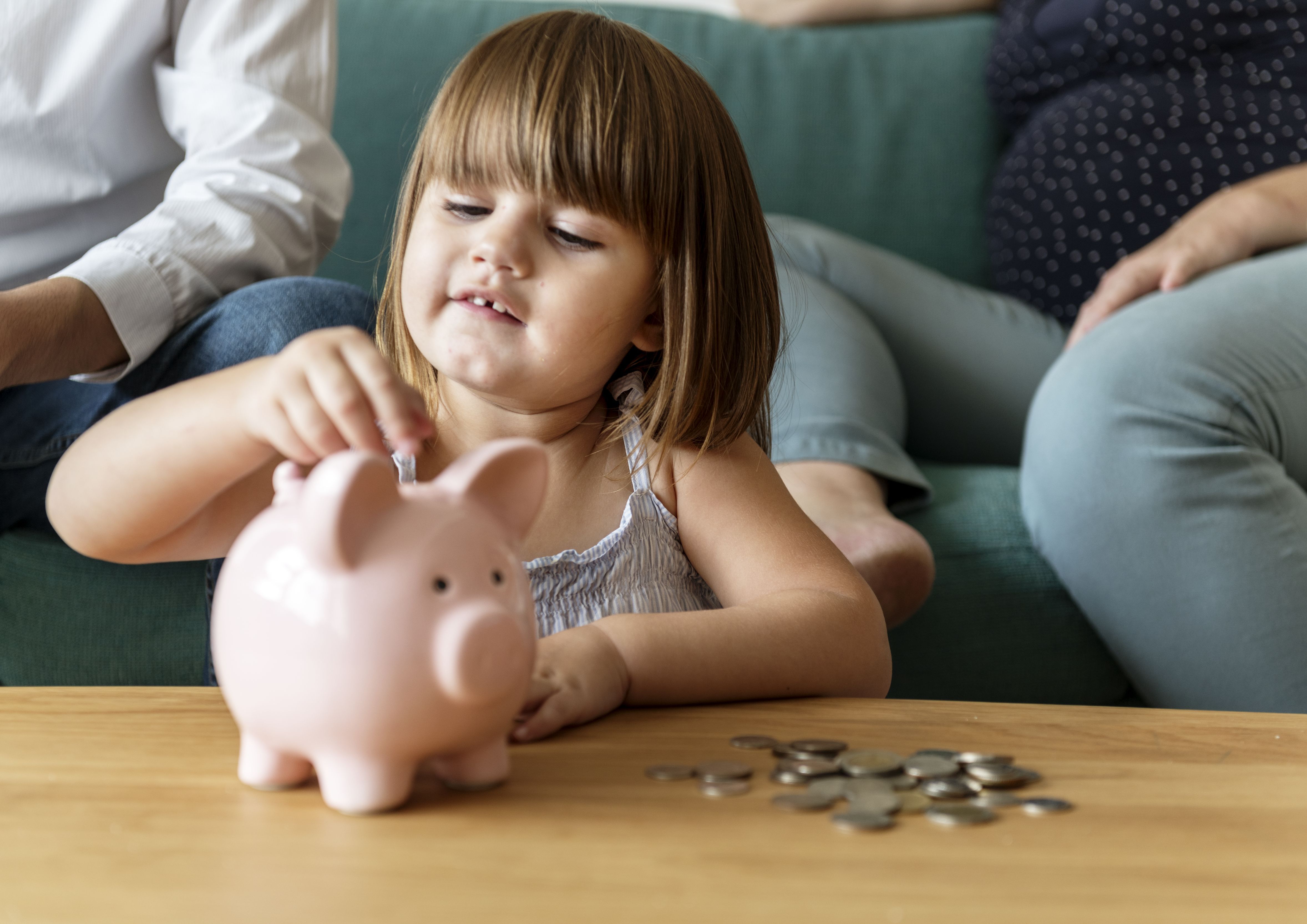 Família economizando dinheiro no cofrinho