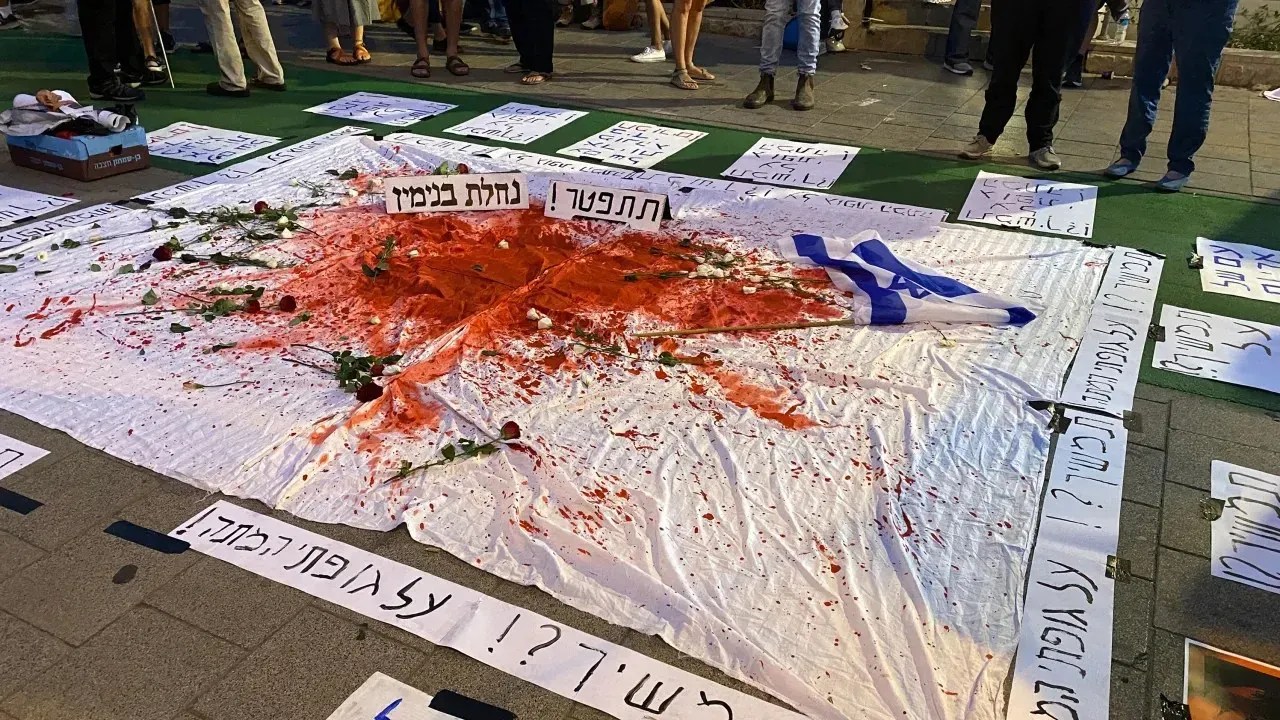 Uma placa que diz "Continuar? Sobre meu cadáver" é vista em um protesto contra Benjamin Netanyahu em Tel Aviv em 14 de outubro de 2023 / Ivana Kottasová/CNN