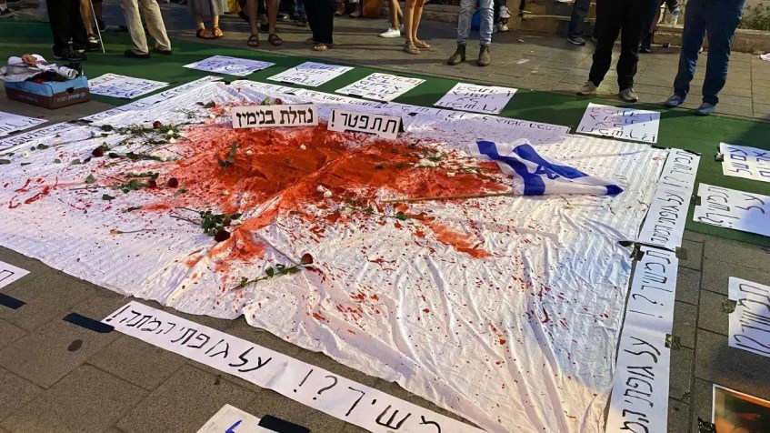 Uma placa que diz "Continuar? Sobre meu cadáver" é vista em um protesto contra Benjamin Netanyahu em Tel Aviv em 14 de outubro de 2023 / Ivana Kottasová/CNN