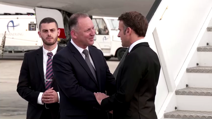 Macron cumprimenta Gil Haskel, da Agência de Cooperação Internacional para o Desenvolvimento de Israel, ao sair do avião / Reuters