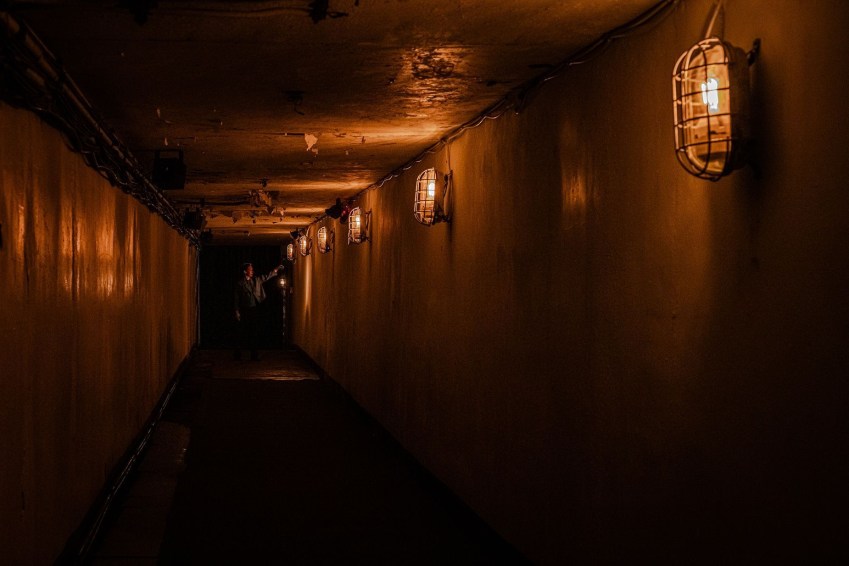 Os visitantes entram na instalação por um túnel estreito e mal iluminado construído na encosta da montanha / YI.ng Lighting Design