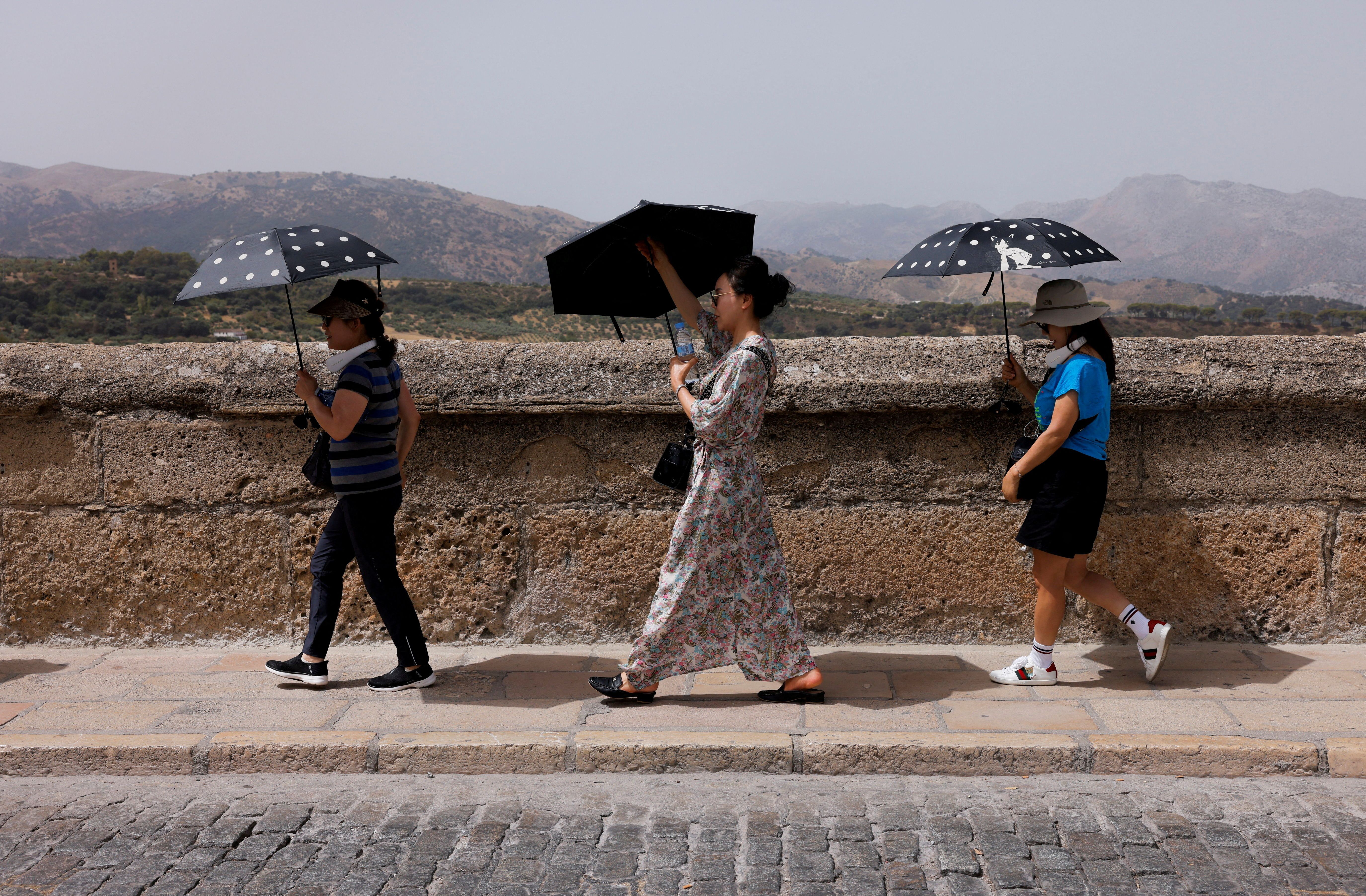 Turistas sul-coreanos se protegem do forte calor em Ronda, na Espanha