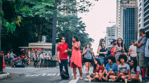 Pessoas sentadas na Avenida Paulista, no centro da cidade de São Paulo