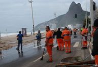 Após forte ressaca, funcionários da Prefeitura do Rio retiram areia da avenida da praia no Leblon