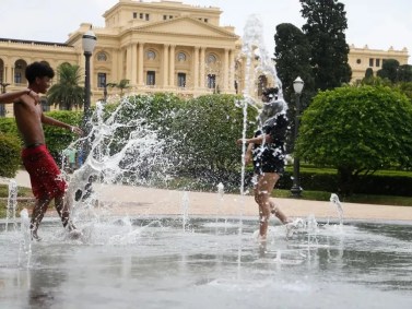 Jovens Luís e Giovana se refrescam no chafariz do Parque da Independência