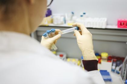 Pesquisador manipula frascos de teste em laboratório