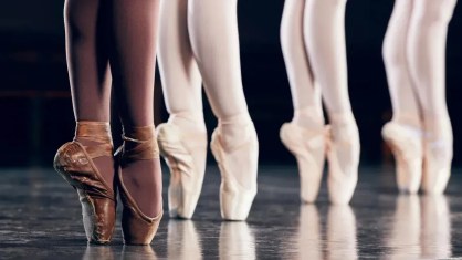 Bailarina com uma sapatilha tingida com maquiagem e tinta para combinar com seu tom de pele.