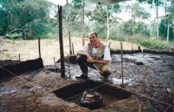 Stéphen Rostain atrás de um pote de cerâmica para cerveja de milho doce (chicha) durante a escavação arqueológica em grande escala em uma plataforma de terra no sítio Sangay, Vale Upano, Equador
