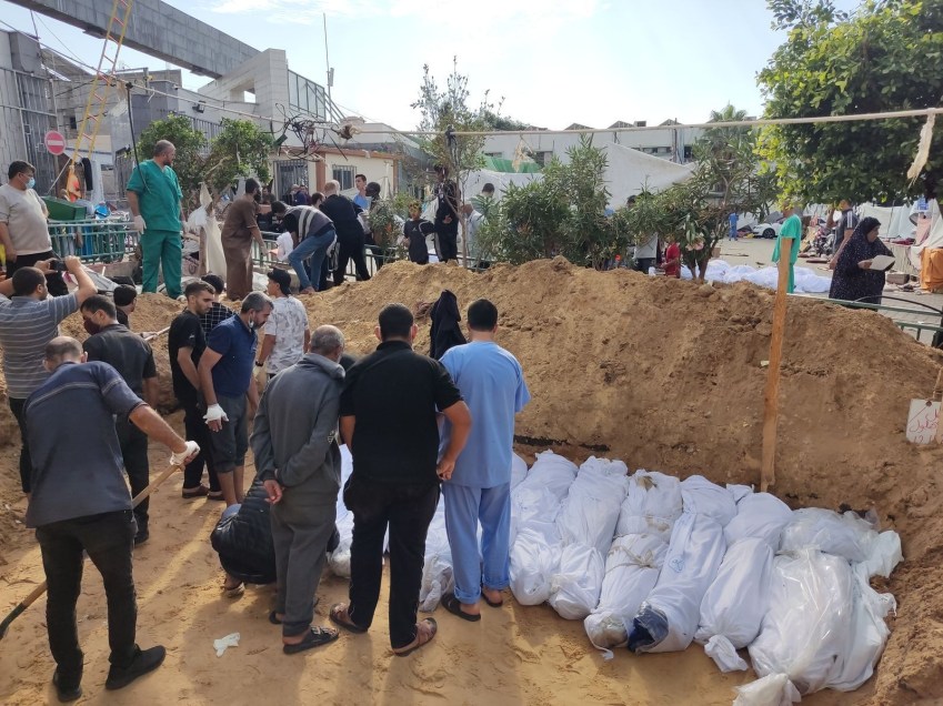 Médicos e outras pessoas cavam uma vala comum para mortos no pátio do Hospital Al-Shifa em Gaza em 14 de novembro de 2023 / Khader Al Za’anoun/CNN