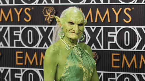 Drag Princess Poppy vestida do personagem Duende Verde no tapete vermelho da 75ª edição do Emmy