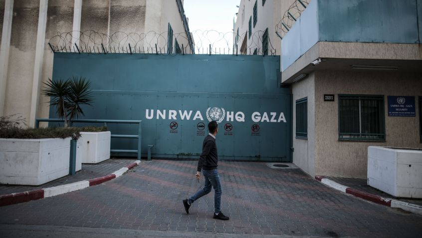Homem caminha em frente ao prédio da Agência de Assistência e Obras das Nações Unidas (UNRWA) na Cidade de Gaza • Ali Jadallah/Agência Anadolu via Getty Images