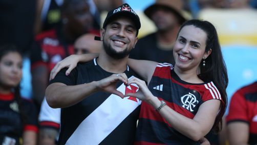 Casal em clássico entre Vasco e Flamengo com torcida dos dois clubes