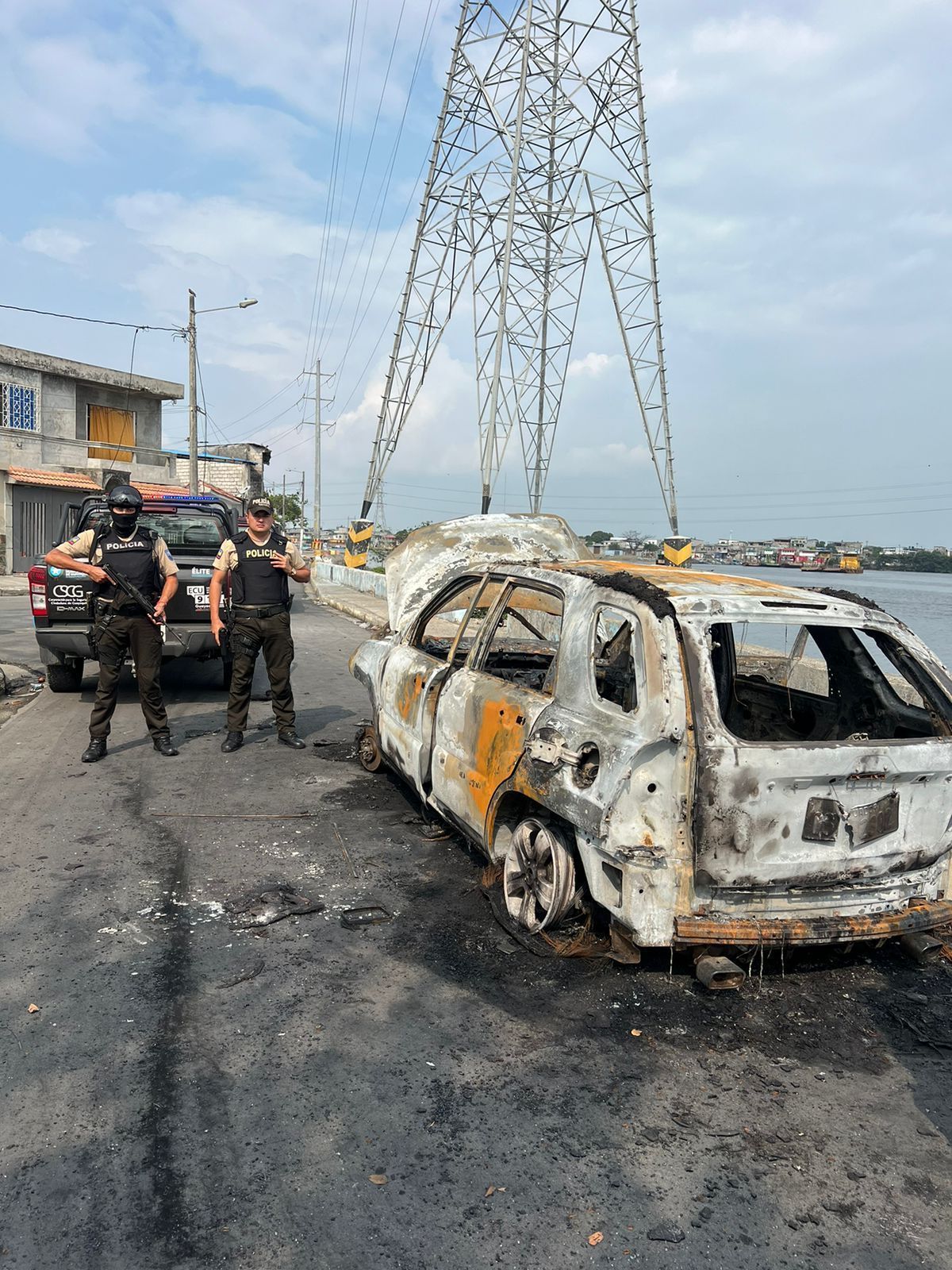 Policiais ao lado de carro incendiado em região dominada pelo tráfico em Guayaquil / Divulgação/Polícia Nacional do Equador