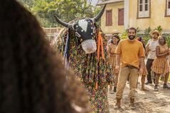 Primeira fase de Renascer: José Inocêncio (Humberto Carrão) observa a chegada do Bumba Meu Boi e se encanta por Maria Santa (Duda Santos) ao vê-la pela primeira vez