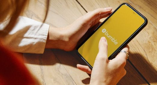 mulher segura um celular com o aplicativo do bumble aberto