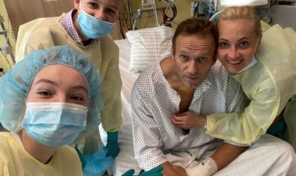 Alexei Navalny em uma cama de hospital, em Berlim, na Alemanha, com a esposa e seus dois filhos durante seu tratamento após ser envenenado.