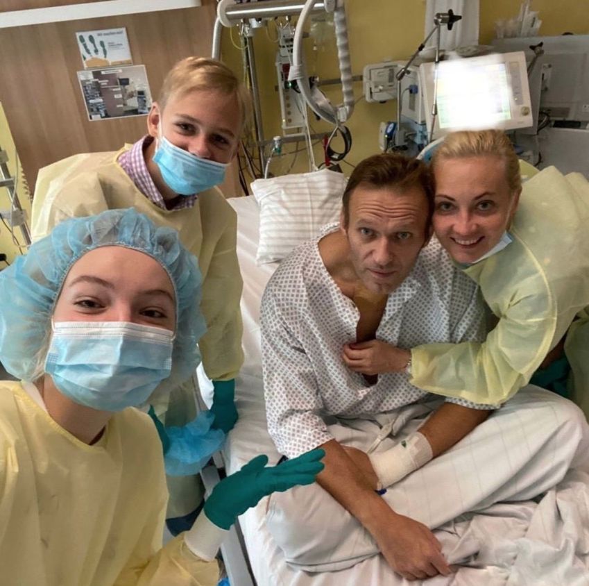 Alexei Navalny em uma cama de hospital, em Berlim, na Alemanha, com a esposa e seus dois filhos durante seu tratamento após ser envenenado. / Handout/Anadolu Agency via Getty Images