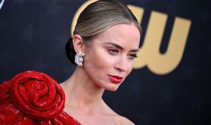 Emily Blunt em primeiro plano com o rosto em evidência em uma foto durante o evento