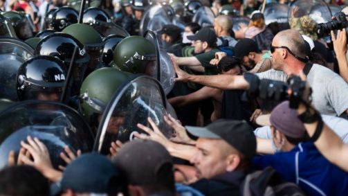 Pessoas entram em confronto com policiais enquanto protestam do lado de fora do Congresso Nacional durante o debate sobre o projeto de lei de reforma econômica do presidente da Argentina, Javier Milei
