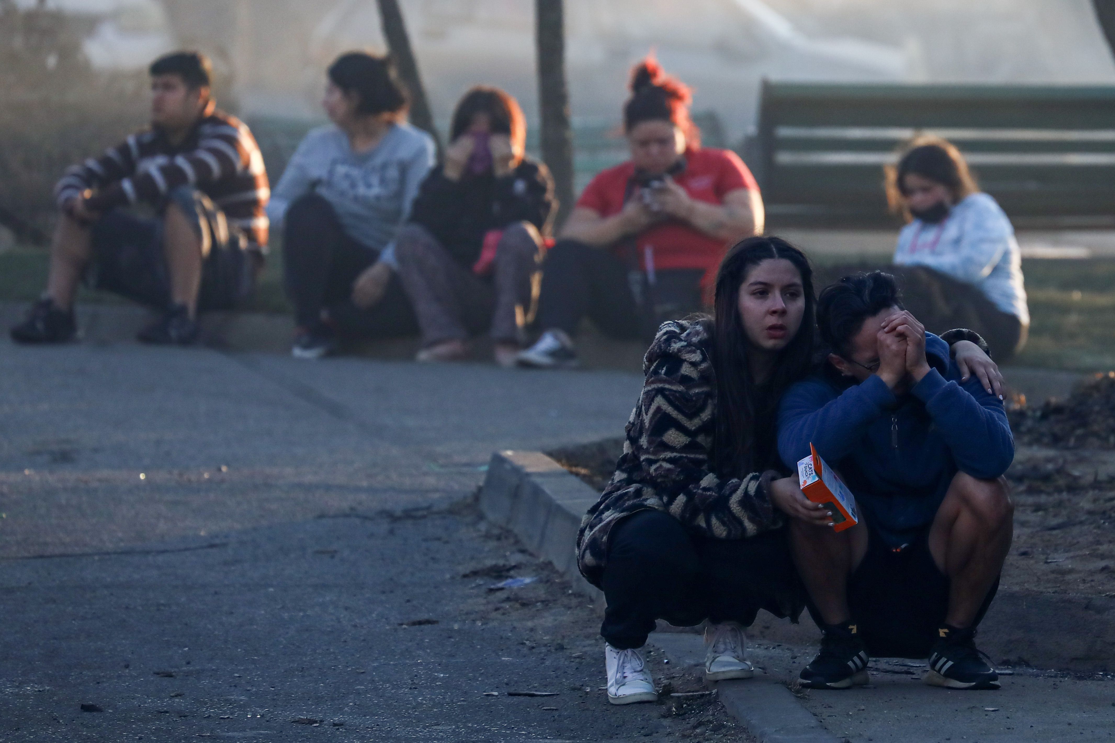 Pessoas se consolam após perderem sua casa em consequência de um incêndio florestal que deixou milhares de casas destruídas nas colinas de Vina del Mar, Chile, em 3 de fevereiro de 2024.