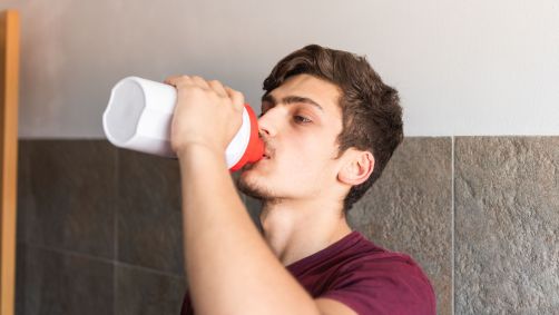 Jovem tomando suplemento alimentar esportivo
