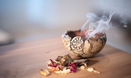 um bowl com fumaça e ervas ao lado