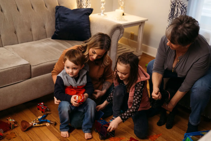 Victoria Hill e seus dois filhos brincam com brinquedos na sala da casa de sua mãe em Wethersfield / Victoria Hill e seus dois filhos brincam com brinquedos na sala da casa de sua mãe em Wethersfield